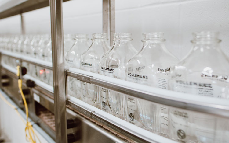 Glass bottles on the bottling line about to get filled with milk